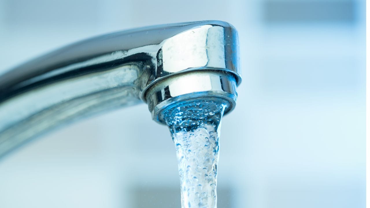 stock image of a water faucet with water coming out
